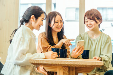 女子会でスマホを見る女性たち
