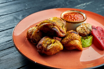 A classic oriental dish is a grilled chicken sish kebab served in a pita with onions and red sauce. Black wood background. Sashlik