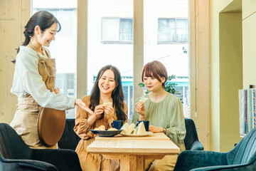 Obraz premium レストランで食事する女性とホールスタッフ 