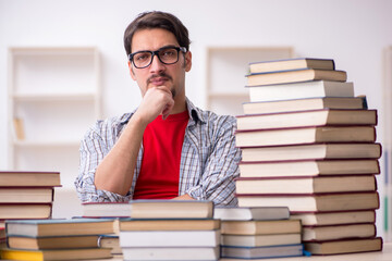 Young male student and too many books in the classroom