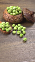 Fresh green peas in wooden bowl on wooden background.
