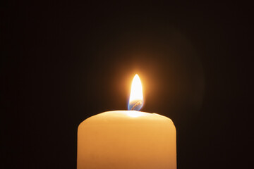 Light from a wax candle burning in the dark