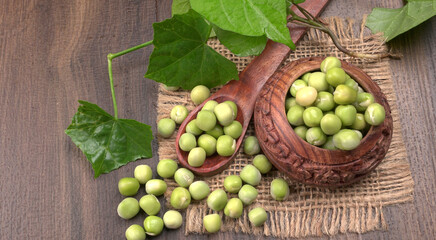 Fresh green peas in wooden bowl on wooden background.