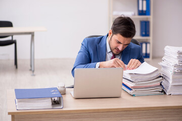 Young male employee and too much work in the office