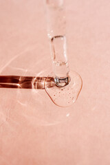 A drop of cosmetic oil falls from the pipette