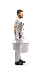 Full length profile shot of a painter in a white uniform carrying two buckets