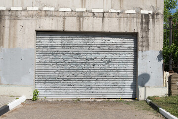 An old, peeling sheet of iron. Fence or garage door. The influence of atmospheric precipitation on the paintwork