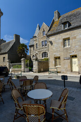 table de bar sur une ancienne rue d'une ville du Finistère en Bretagne à Roscoff avec commerce et ciel bleu