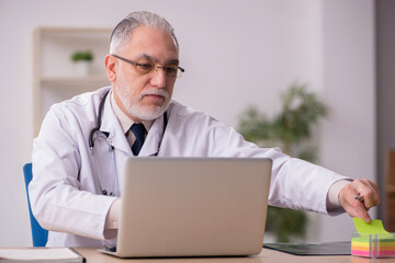 Old male doctor working in the clinic