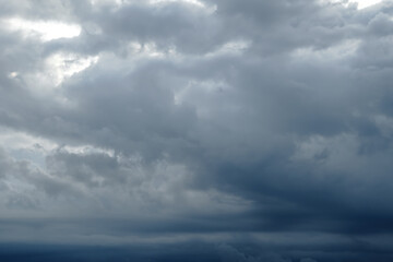 Naklejka na ściany i meble Dark sky full of clouds before the rain. Rain clouds and contrasting sunshine. Rain clouds.