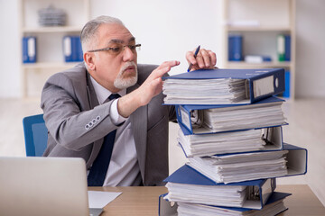 Old male employee unhappy with excessive work in the office