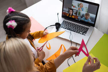Online education of children. Mother and daughter of preschool watching a video lesson call chat creative course art drawing using lapott at home.