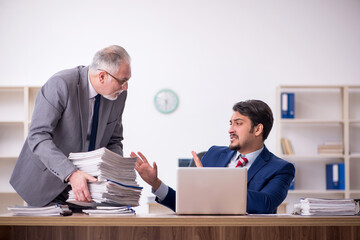 Two male employees and too much work in the office