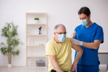 Old male patient visting young male doctor in vaccination concep