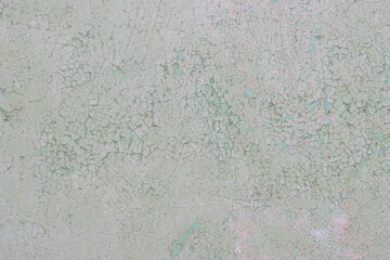 Peeling paint on the wall. Old concrete wall with cracked flaking paint. Weathered rough painted surface with patterns of cracks and peeling. High resolution texture for background and design. Closeup