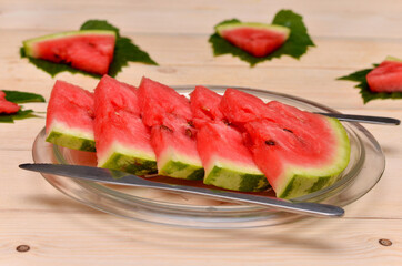 slices of watermelon on a plate and cutlery serving close-up