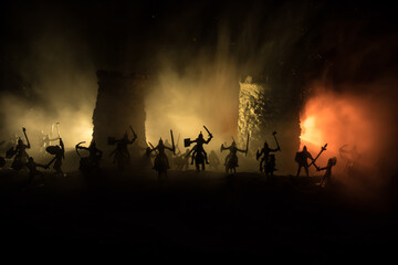 Fototapeta premium Medieval battle scene. Silhouettes of figures as separate objects, fight between warriors at night. Creative artwork decoration. Foggy background.
