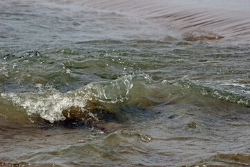 Close-up of a small ocean wave breaking near to the shore