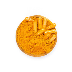 Dry organic turmeric powder in capsule and wooden spoon on white background