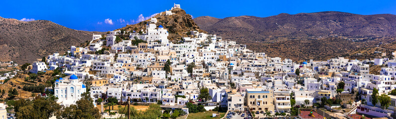 Fototapeta na wymiar Picturesque authentic Ios island. View of scenic old town Chora with whitewashed houses and blue churches