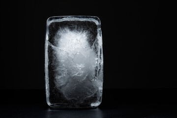 Textured ice block on black background, big solid ice cube