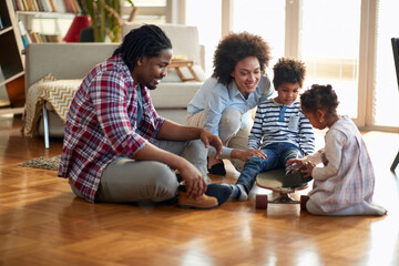 A happy parents playing with their kids on the floor at home. Family, together, love, playtime