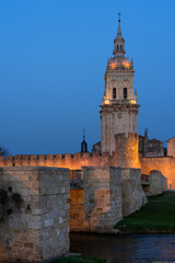 View of the medieval village of Burgo de Osma, the walls and the cathedral tower illuminated at night, Soria, Castilla y León, Spain.