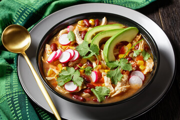 Mexican chicken and tortilla soup on a black plate