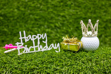 Golf ball with word happy birthday are on green grass with gifts