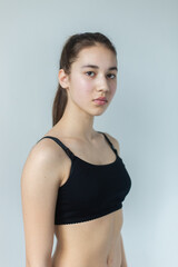 Fototapeta premium Natural beauty brunette model no make up in swimsuit posing in studio on isolated background. Model tests, natural no make up models concept