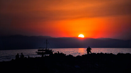 sunset and silhouette people and boat by the sea - Antalya city in turkey