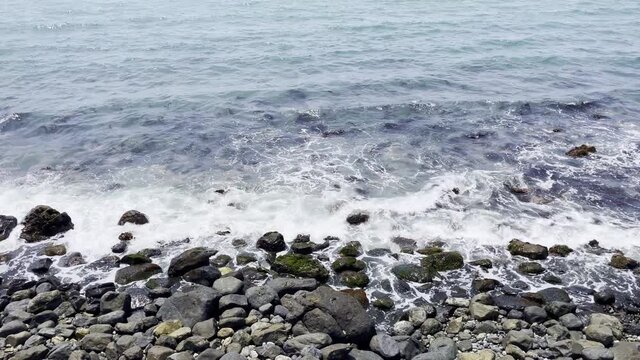 waves crashing against a reef in the blue sea.