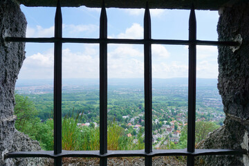 Ausblick aus einem mit Gitterstäben gesichertes Fenster vom Bismarckturm im Habichtswald