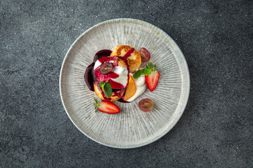 Lush cheesecakes with strawberries, peaches, cream and fruit jam. Healthy nutritious breakfast. Ready menu for the restaurant. Neutral gray blue textured background