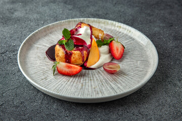 Lush cheesecakes with strawberries, peaches, cream and fruit jam. Healthy nutritious breakfast. Ready menu for the restaurant. Neutral gray blue textured background