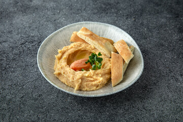 Hummus with turkey or chicken pate. Ready menu for the restaurant. Neutral gray blue textured background