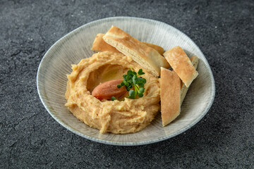 Hummus with turkey or chicken pate. Ready menu for the restaurant. Neutral gray blue textured background