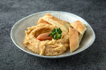 Hummus with turkey or chicken pate. Ready menu for the restaurant. Neutral gray blue textured background