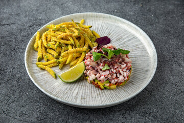 Octopus tartar with avocado and tender zucchini in batter. Ready menu for the restaurant. Neutral gray blue textured background