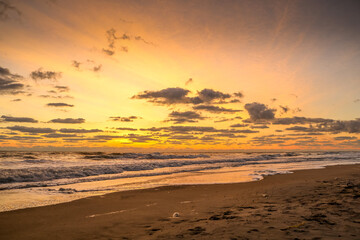 Bright ocean sunrise with spotty clouds