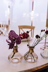 Champagne glasses. Candles and flowers. Banquet table decoration.