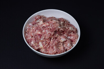 Fresh minced meat on a black background. Minced pork meat.