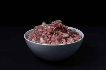 Fresh minced meat on a black background. Minced pork meat.