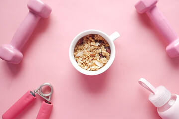 mixed nut in a bowl, milk and dumbbell on table 