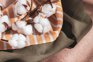 Serving napkins and a branch of cotton on a beige background