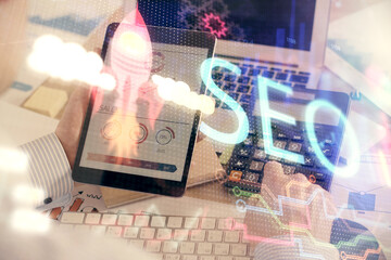 Multi exposure of man's hands holding and using a digital device and seo drawing. search...