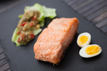 baked salmon fillet with homemade guacamole and quail eggs halves