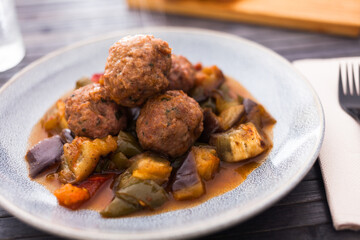 baked meatballs with stewed eggplant, zucchini, green peppers and tomatoes with haze in bowl