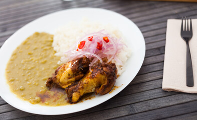 traditional Peruvian dish. chicken wings with pea puree, rice and pickled onions