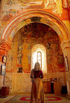 Female visitor being impressed with the medieval frescoes inside the church of Gerati Monastery Complex, Kutaisi, Georgia